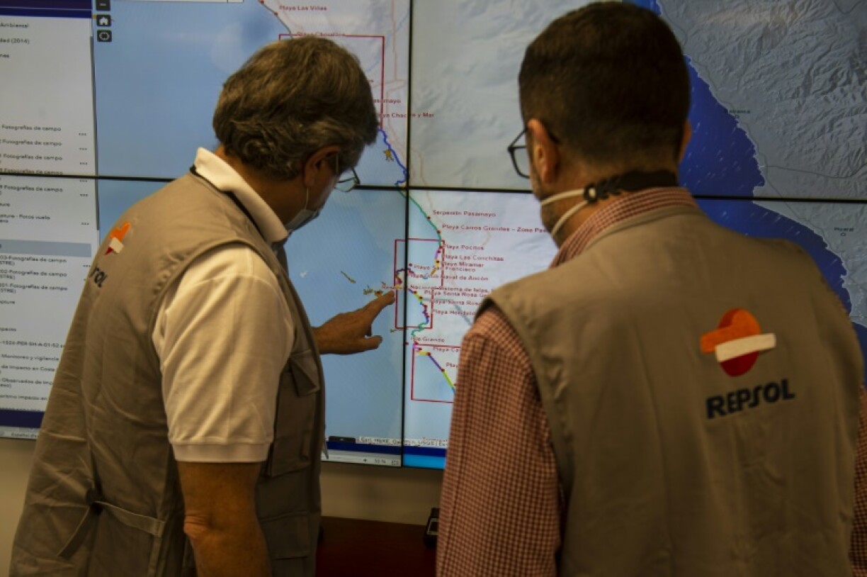 Des employés de la compagnie pétrolière espagnole Repsol montrent sur une carte les zones polluées par une marée noire, le 3 février 2022 au Pérou