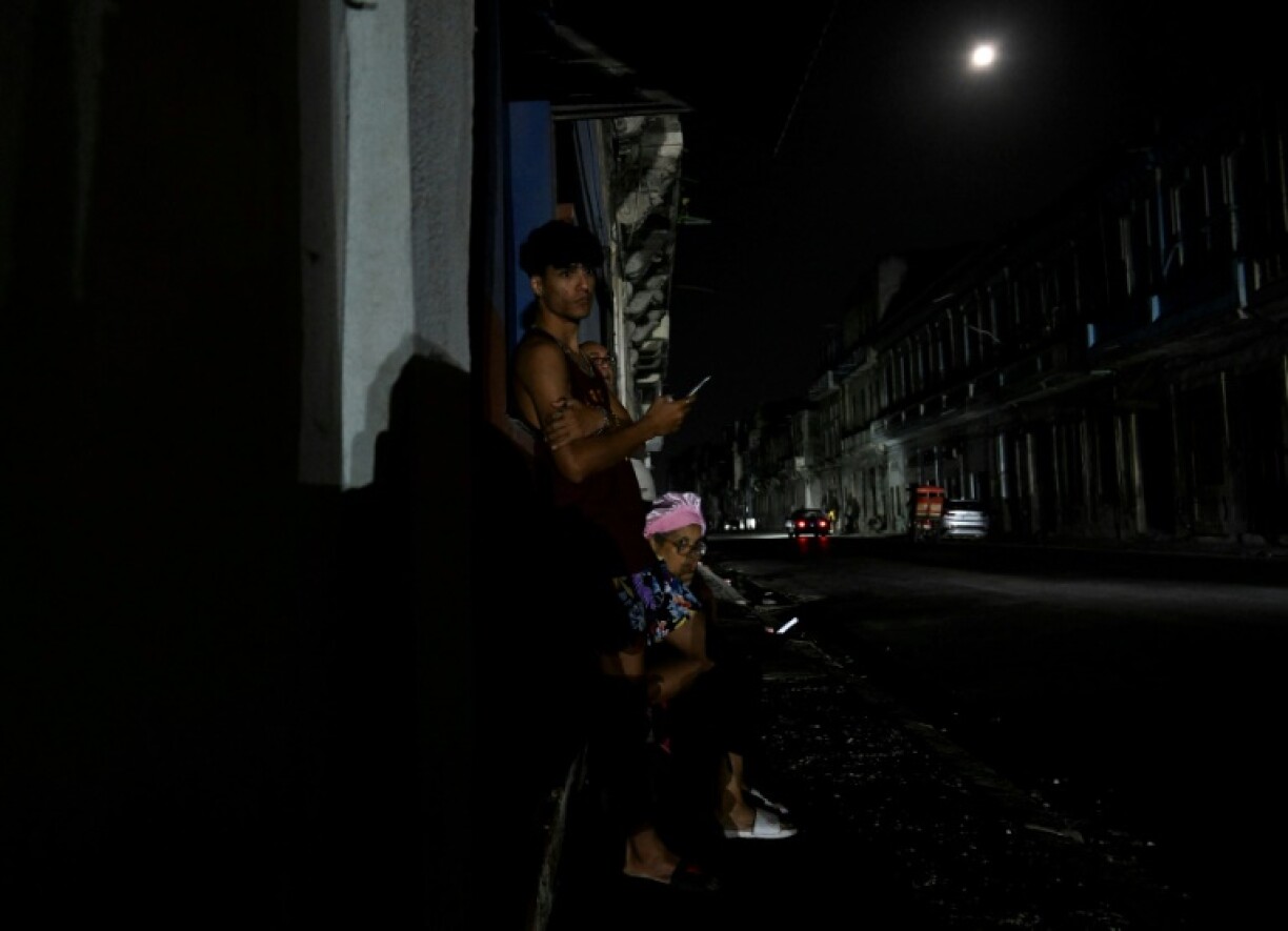 Des habitants sur le pas de porte d'une maison à La Havane pendant une panne générale de courant à Cuba, l e 14 mars 2025