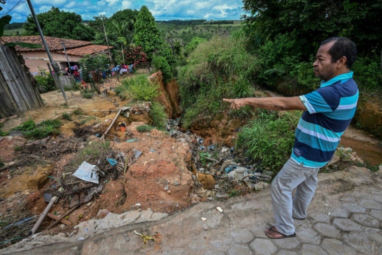 Isaias Neres Cardoso Aguiar montre un cratère près de sa maison, à Buriticupu, dans l'Etat brésilien du Maranhao (nord-est), le 21 avril 2023.