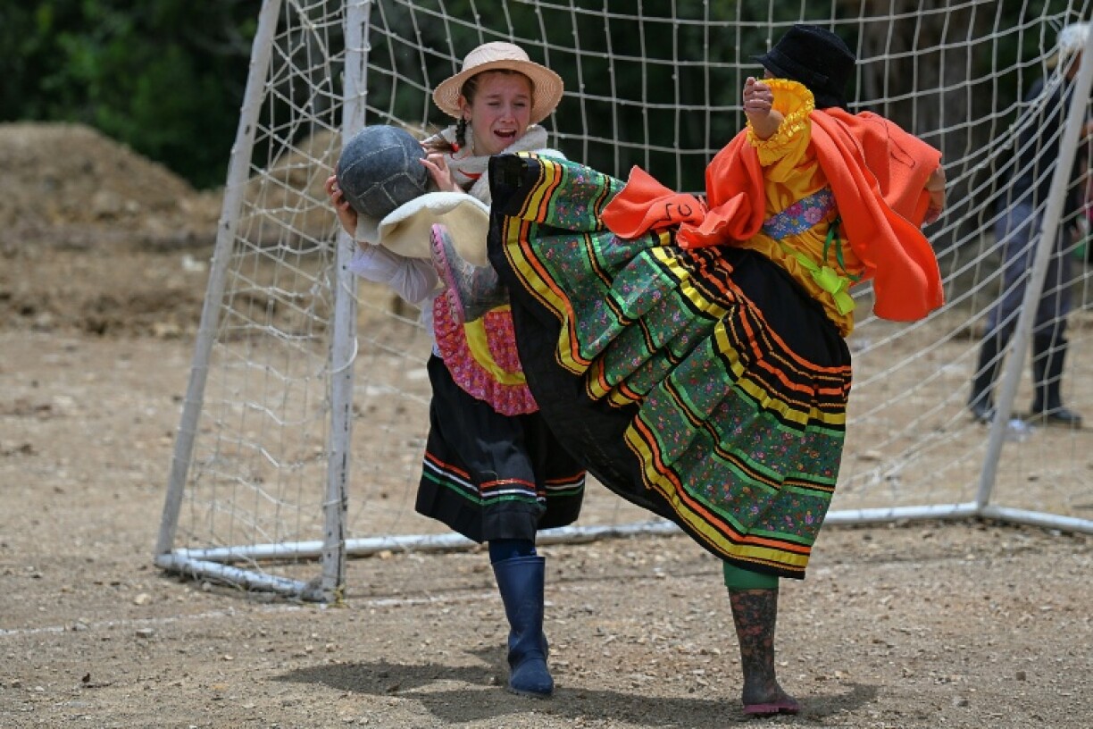 Players challenge for the ball in the 'Boot, Poncho and Hat' football tournament
