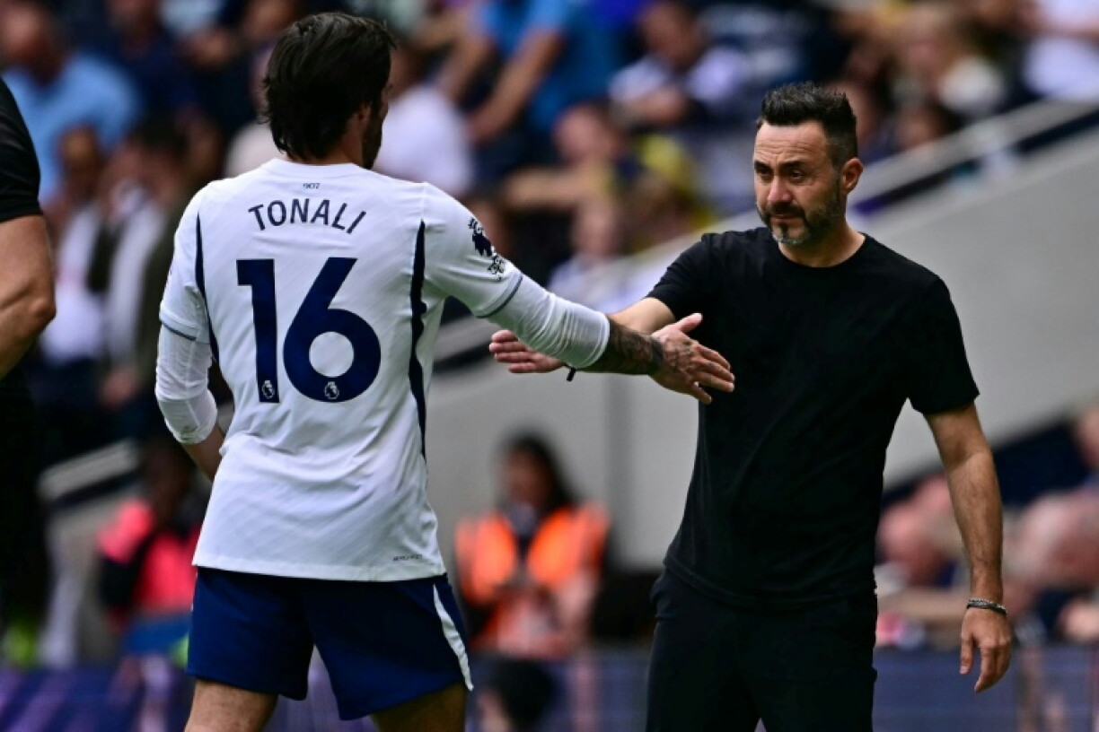 L'entraîneur de Tottenham Roberto De Zerbi serre la main de son attaquant Sandro Tonali lors de son remplacement, le 19 septembre 2026 à Londres