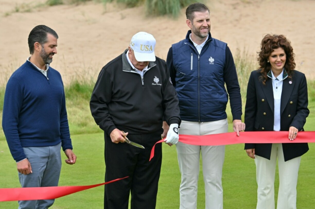 US President Donald Trump cuts the ribbon on the first tee to officially open the Trump International Golf Links course in Balmedie, Aberdeenshire