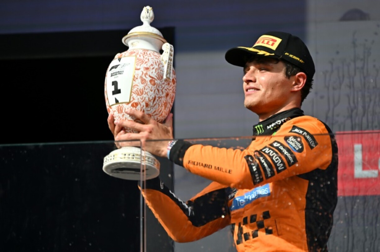 McLaren's Lando Norris raises the trophy after winning the Hungarian Grand Prix