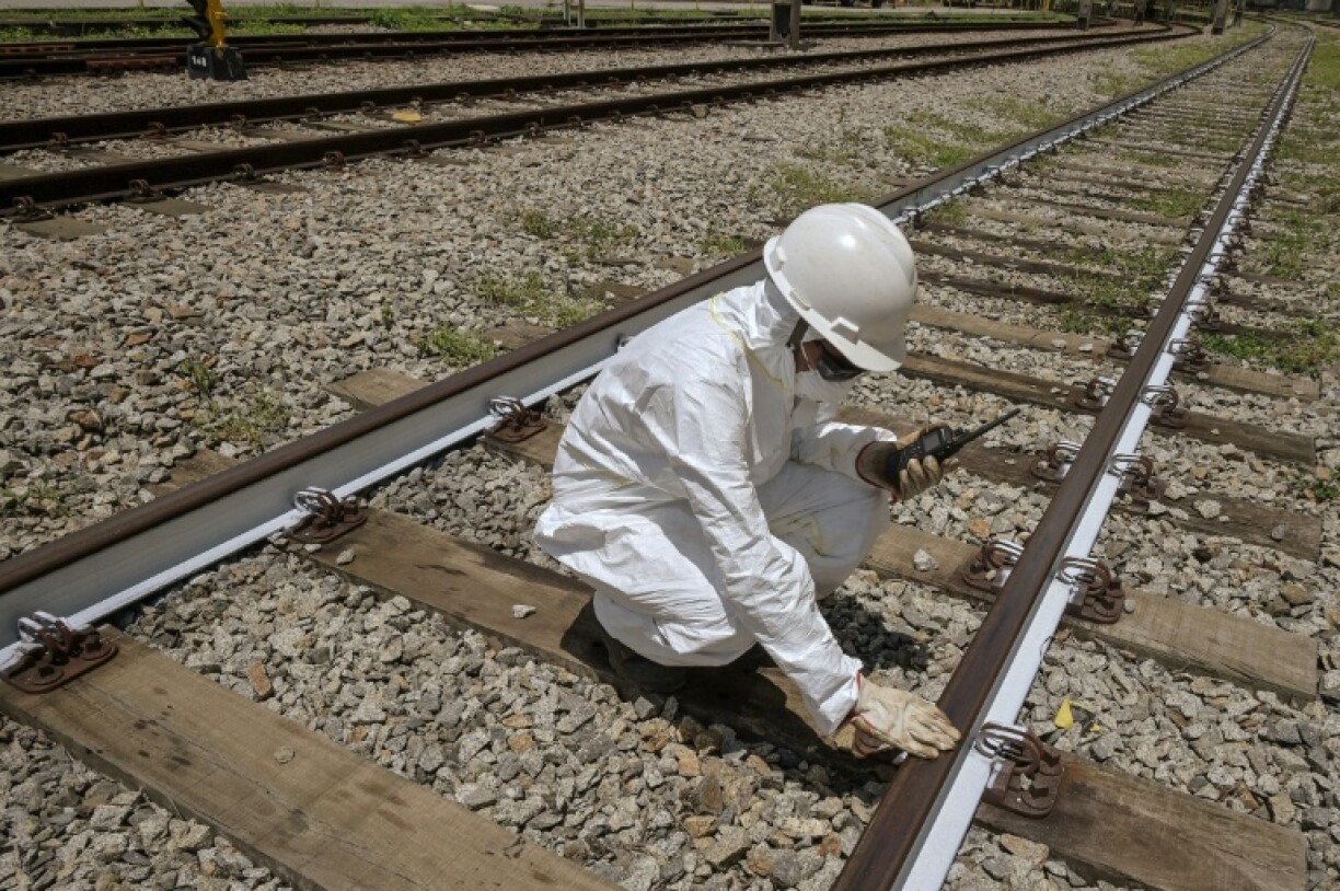 An Employee of ViaMobilidade - a company that manages subway and train lines in the Sao Paulo metropolitan area - takes the temperature of railway tracks in Osasco, Sao Paulo state, Brazil on February 24, 2025