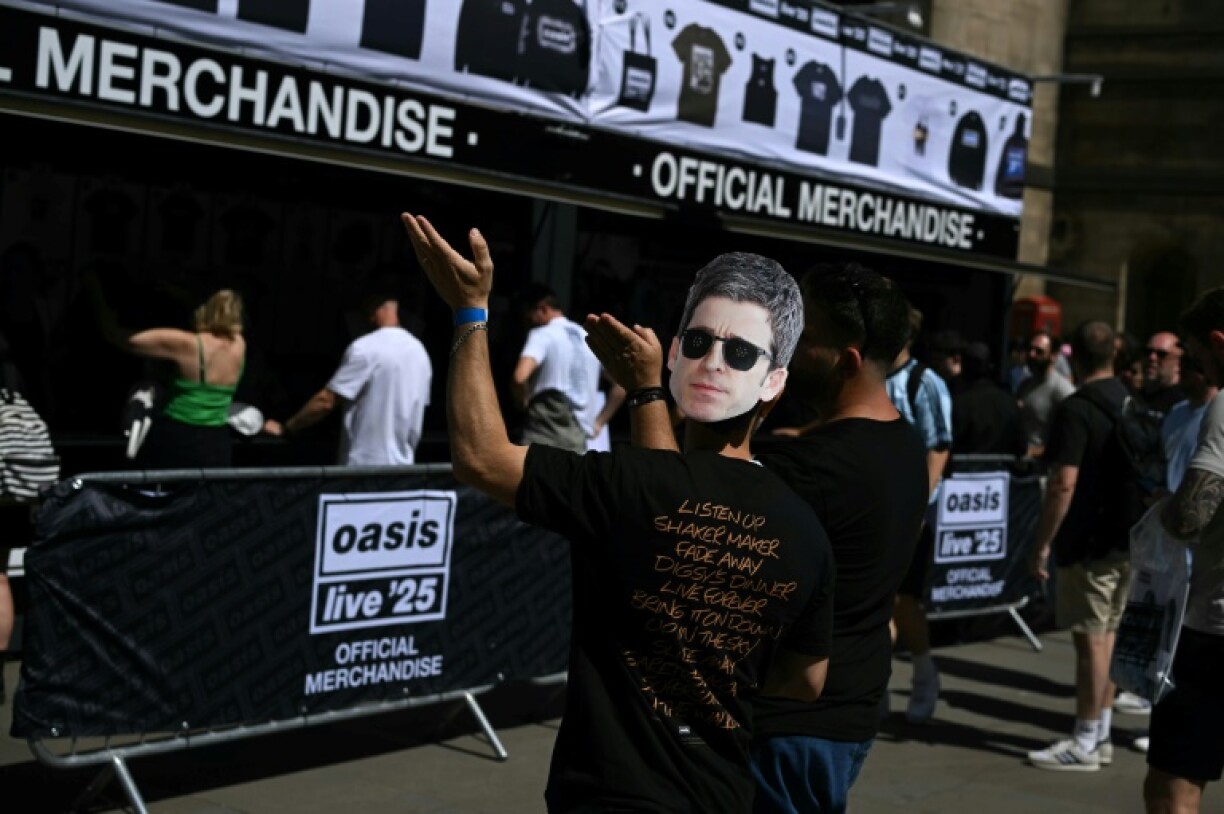 An Oasis fan, wearing a Noel Gallagher mask, queueing to buy official merchandise