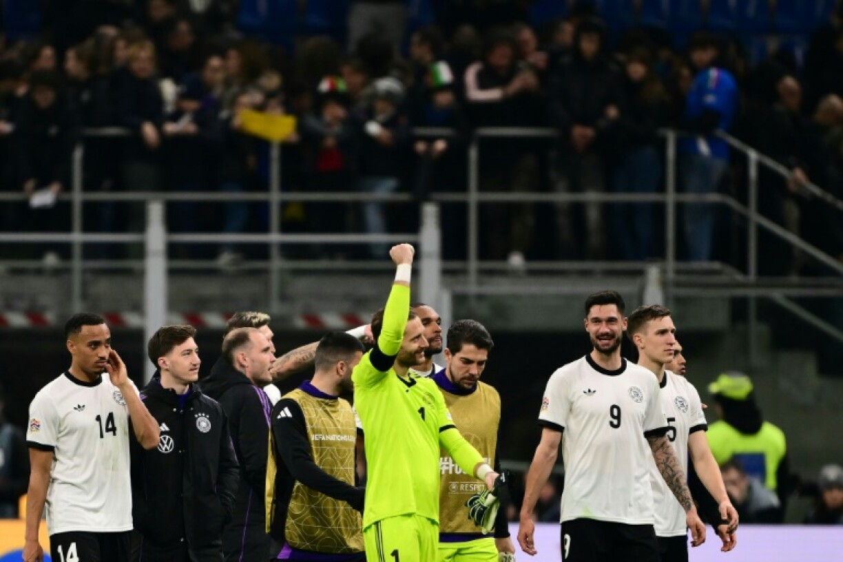 Germany goalkeeper Oliver Baumann celebrates with team-mates after winning the Nations League quarter-final first leg against Italy in Milan