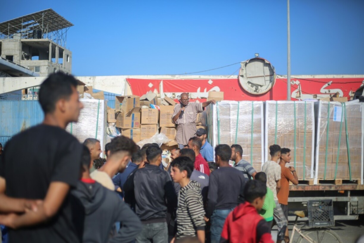 Displaced Palestinians gather round a truck to receive aid supplies