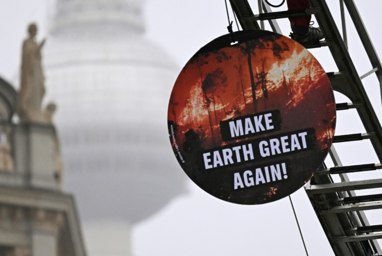 A Greenpeace activist installs a placard reading 'Make Earth Great Again' outside Germany's foreign ministry, which was hosting the climate talks