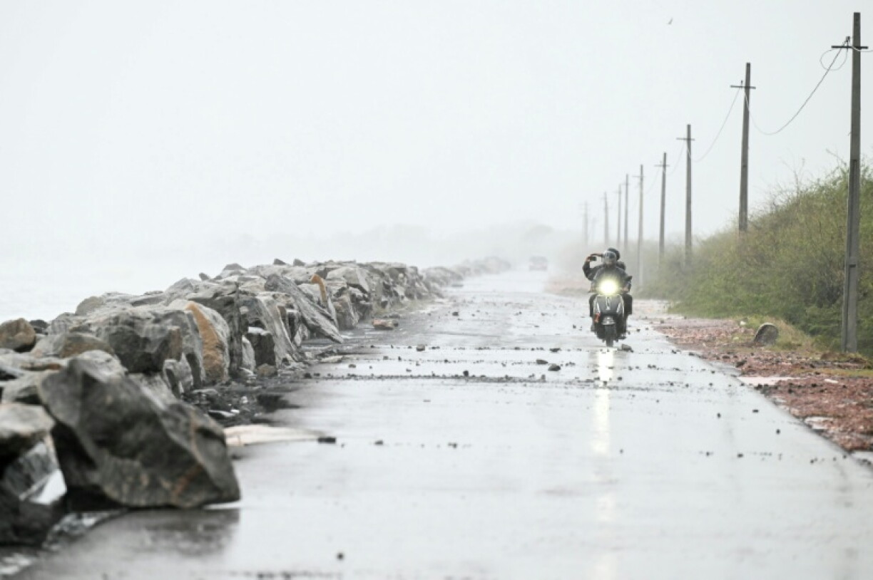 A motorcyclist rides along the Bay of Bengal coast in Andhra Pradesh's Kakinada ahead of cyclone Arnab's expected landfall