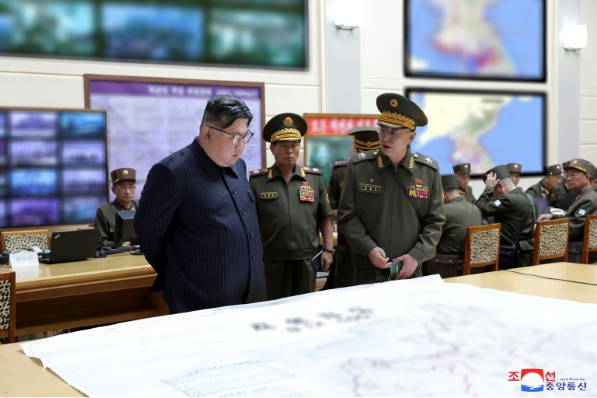 Photo du 29 août 2023 publiée par l'agence nord-coréenne KCNA le 31 août montrant le dirigeant nord-coréen Kim Jong Un (g) inspectant le poste de commandement d'entraînement de l'état-major général de l'Armée populaire coréenne (APC), dans un lieu tenu secret en Corée du Nord