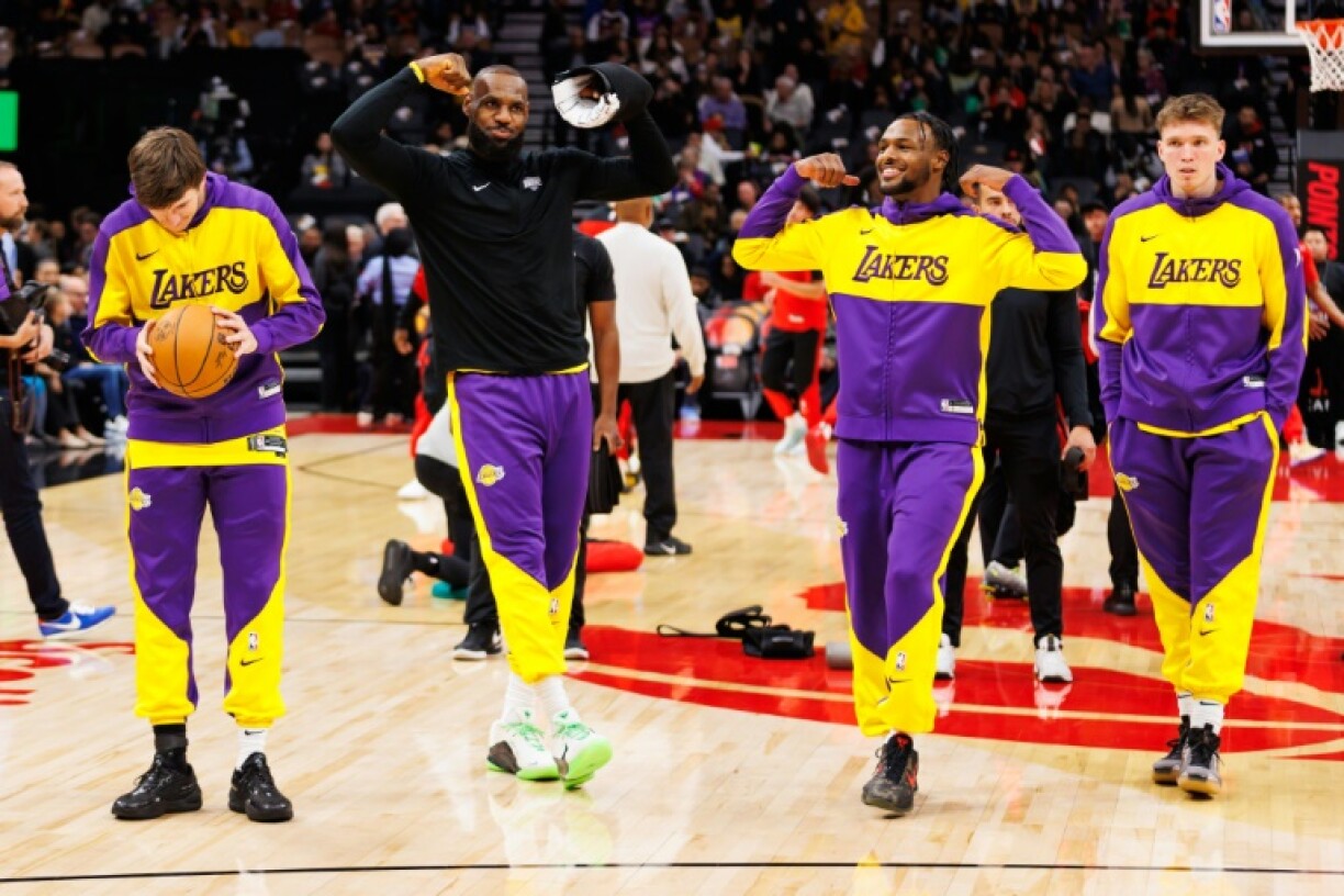 LeBron James and son Bronny James warm up as they prepare to take the court together in an NBA game against the Toronto Raptors