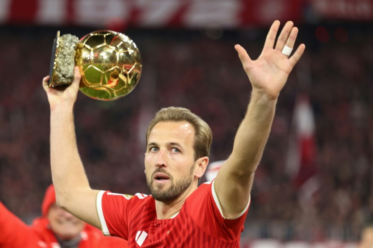 Bayern Munich forward Harry Kane shows off the Ballon d'Or before Saturday's home match with Borussia Dortmund.