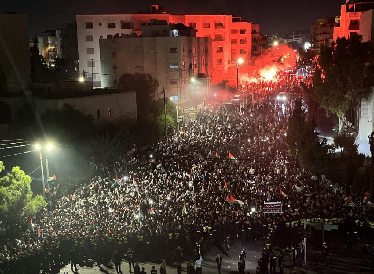 Des personnes tenant des drapeaux palestiniens se rassemblent devant l'ambassade israélienne pour protester contre le bombardement de l'hôpital baptiste Al-Ahli de Gaza, à Amman, en Jordanie, le 18 octobre 2023.
