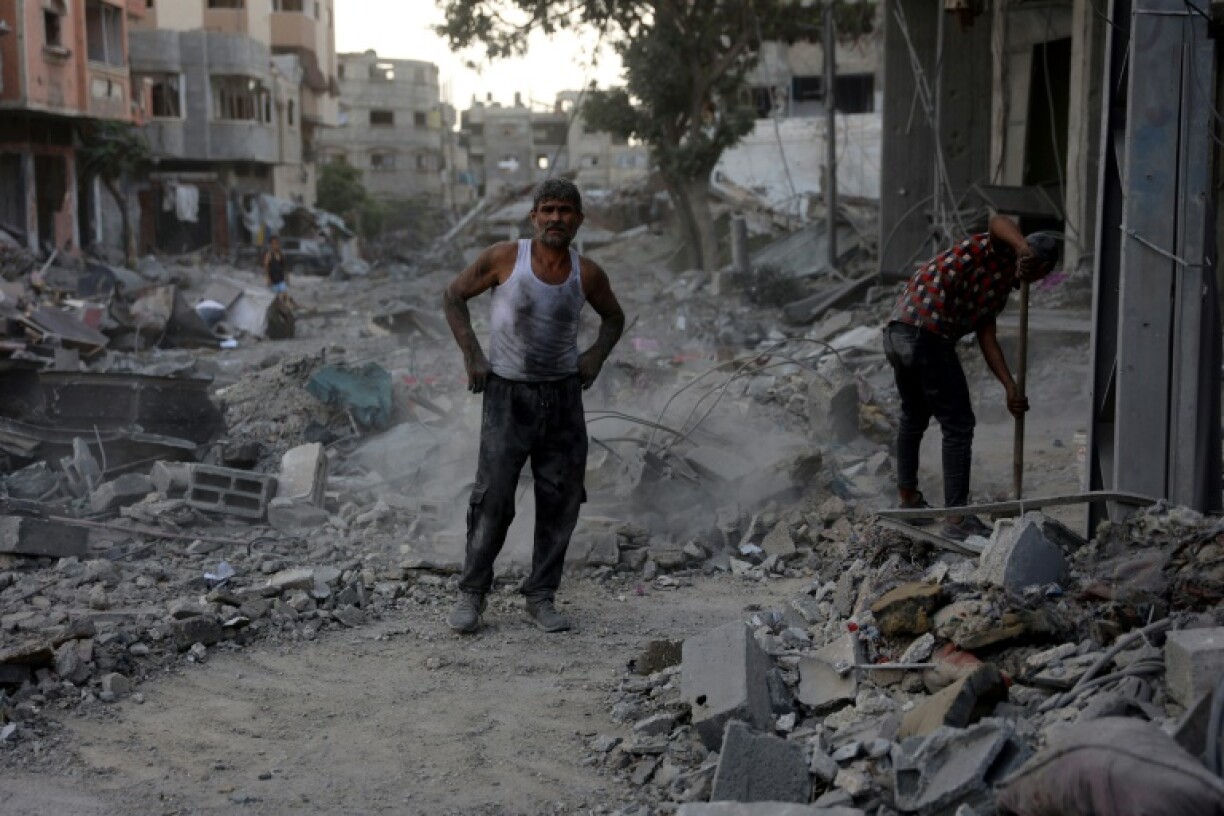 Un Palestinien se tient proche des décombres d'un immeuble résidentiel détruit par une frappe dans la ville de Gaza, le 27 juillet 2024