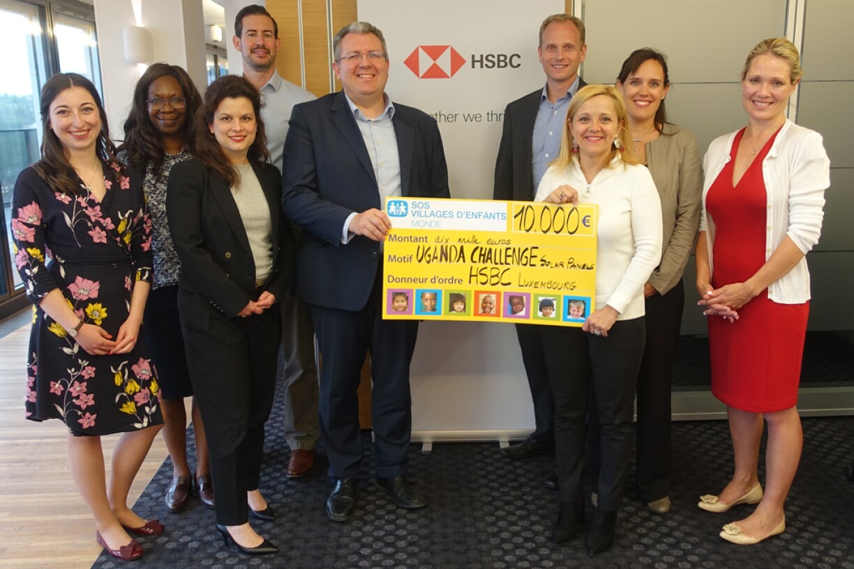 Niccolo Polli, Koen Quintens et les collaborateurs de HSBC remettent un chèque à Sophie Glesener de SOS Villages d'Enfants Monde.