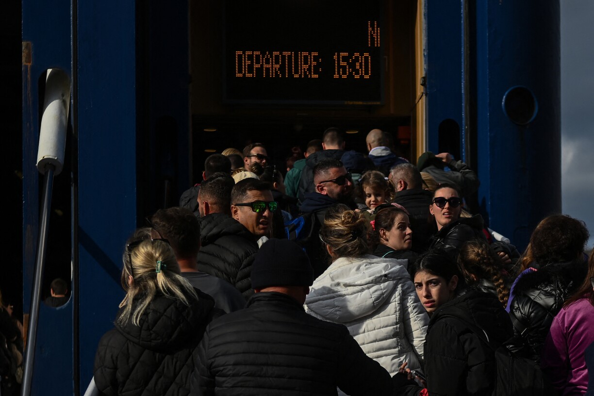 People embark a ferry at the port on the Greek Island of Santorini on February 3, 2025, to leave in the wake of recurring earthquakes.
