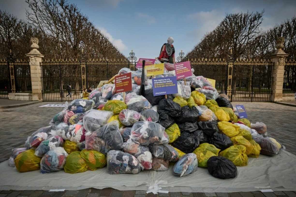 Dustbin bags full of clothes lie outside France's Senate in a March protest