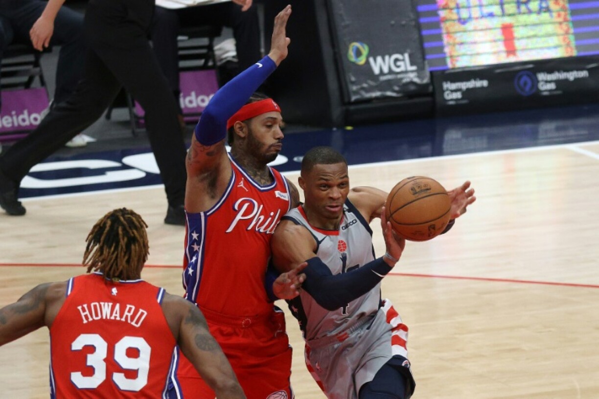 Russell Westbrook (d) des Washington Wizards face à Mike Scott des Philadelphia 76ers en NBA le 12 mars 2021 à la Capital One Arena à Washington