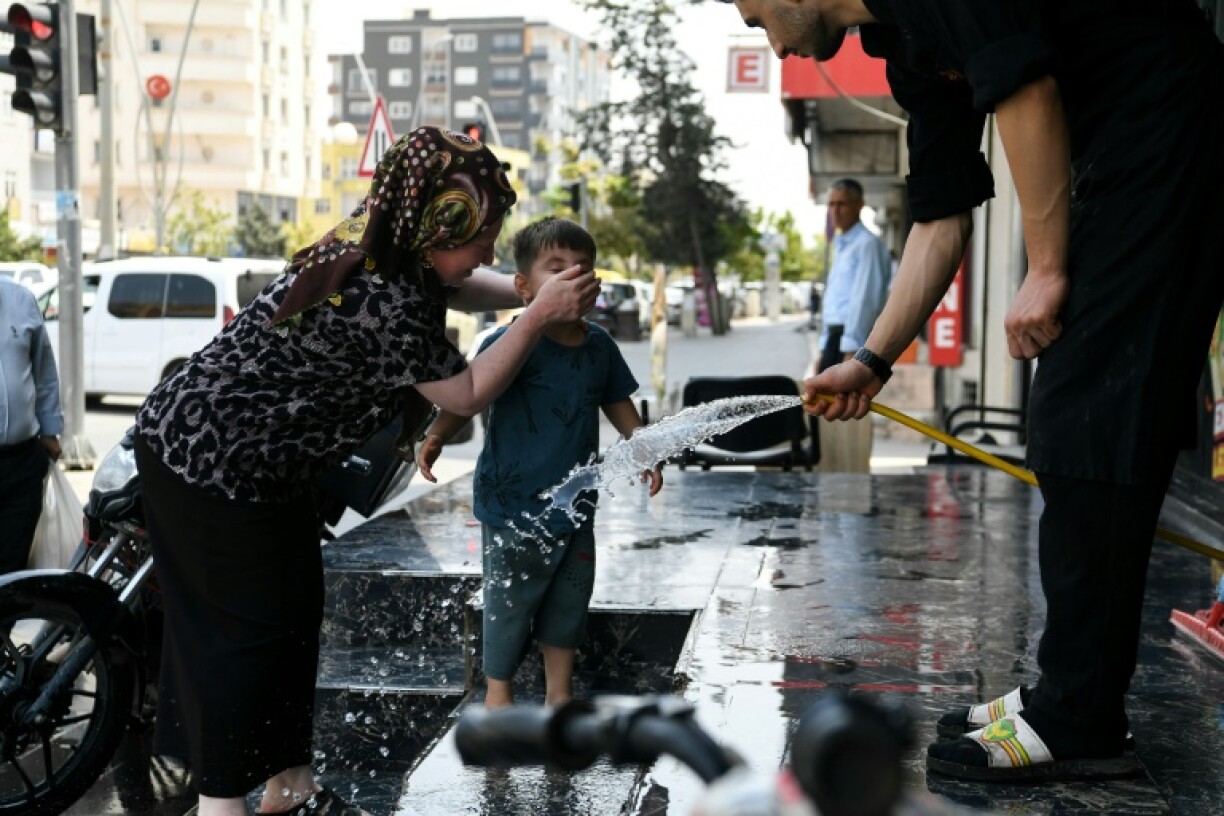 A woman helped her child cool down with water in Silopi