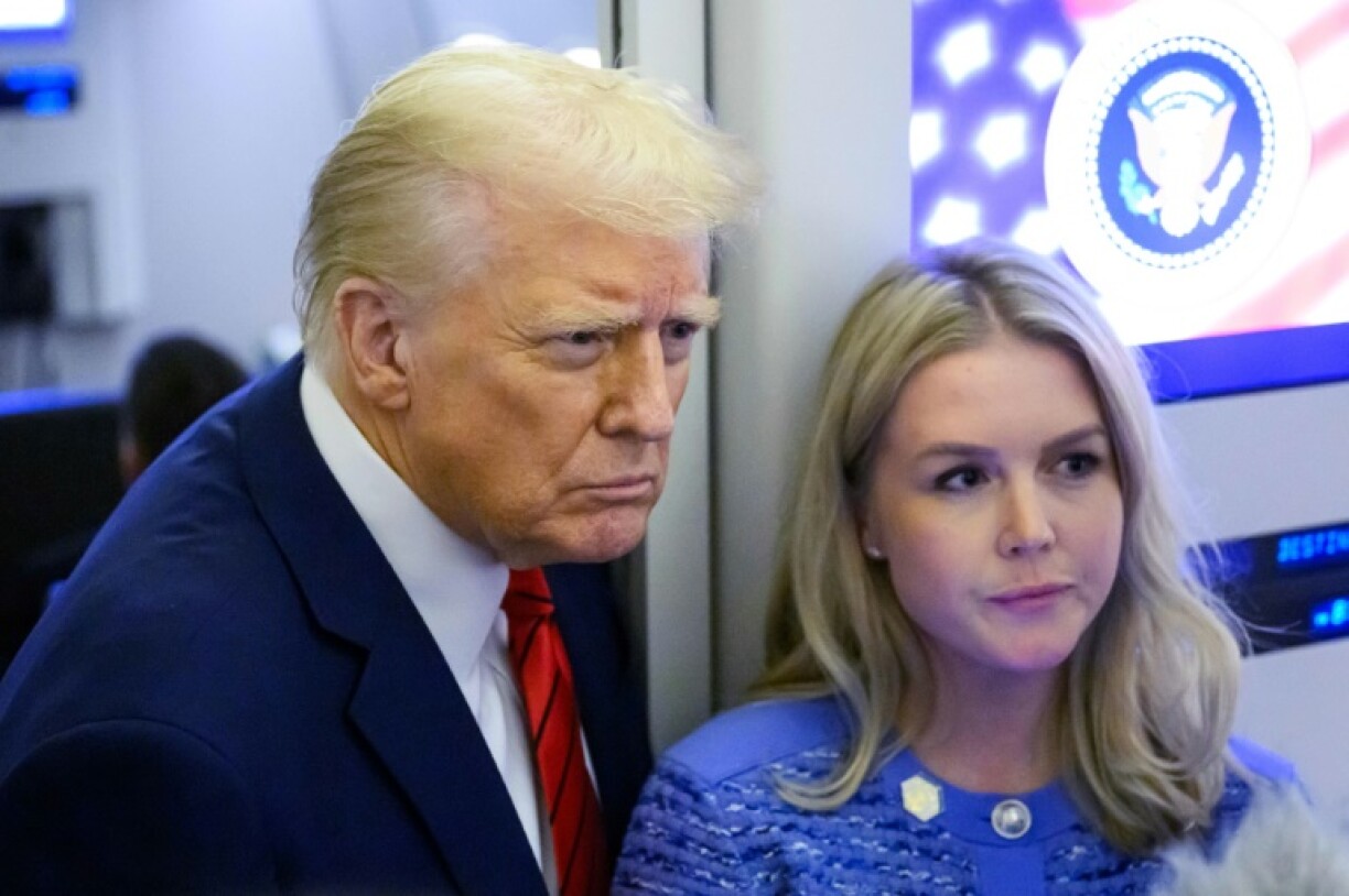 US President Donald Trump, next to White House Press Secretary Karoline Leavitt, speaks to reporters while in flight on Air Force One en route Joint Base Andrews, on January 27, 2025.