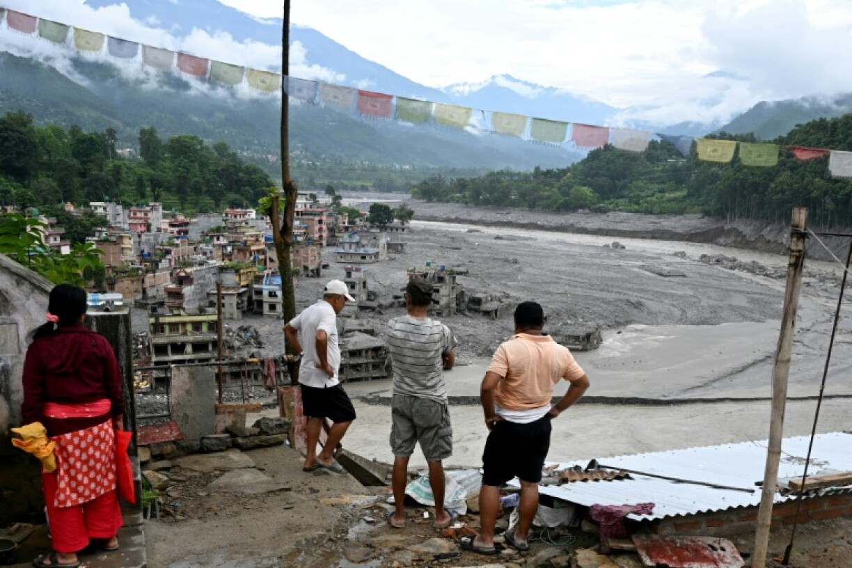 Des habitants observent des maisons endommagées par des crues soudaines à Trishuli Center, dans le district de Nuwakot, le 31 août 2026 au Népal