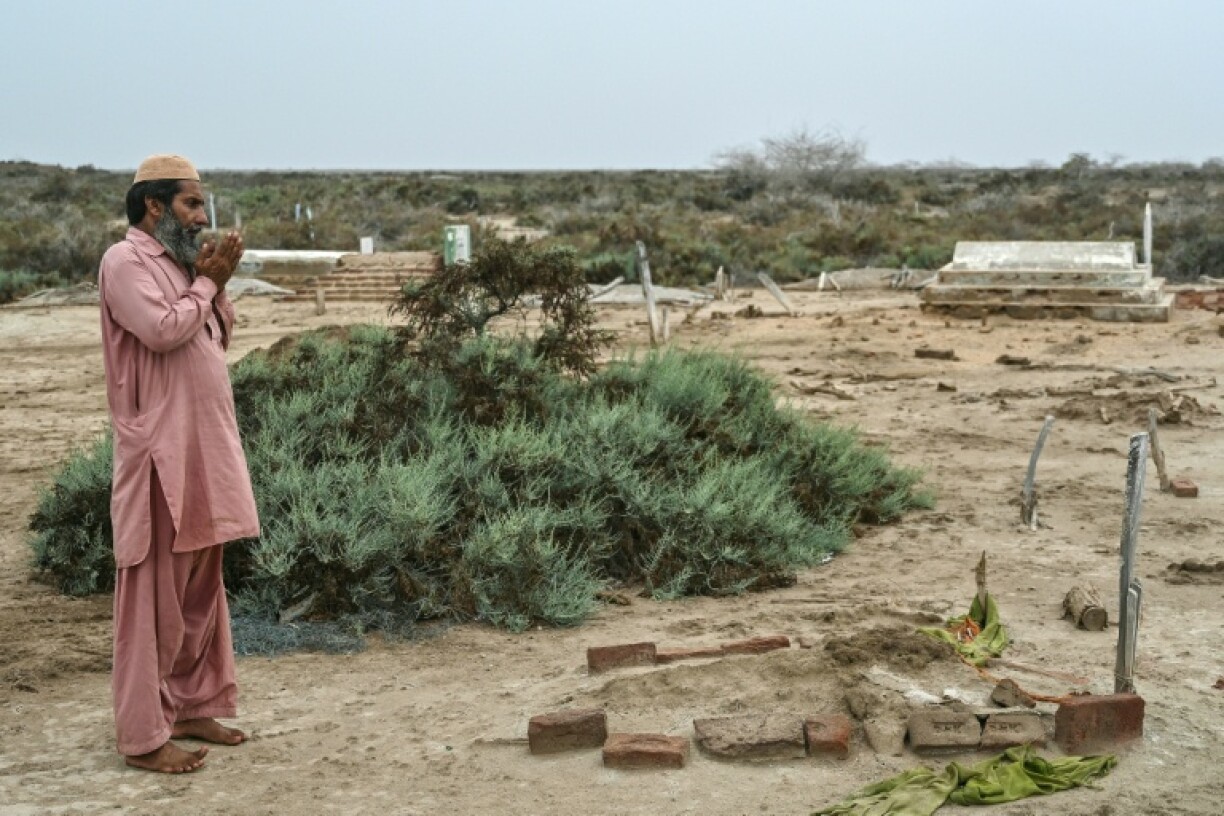 Habibullah Khatti bids a final goodbye to his mother's grave before he abandons his parched island village on Pakistan's Indus delta