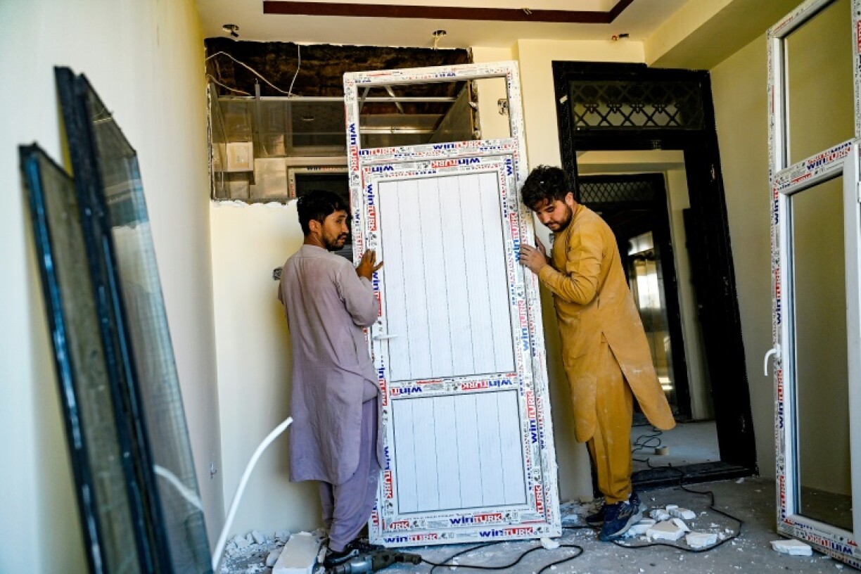 Workers clear furnishings from an apartment due for demolition in Kabul's Dasht-e-Barchi neighbourhood