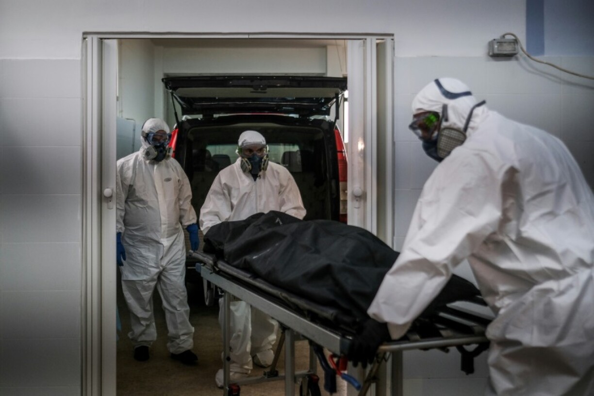 Des employés des pompes funèbres transportent le corps d'une victime du Covid-19 dans un sac mortuaire, aux pompes funèbres d'Amadora, dans la banlieue de Lisbonne, le 29 janvier 2021