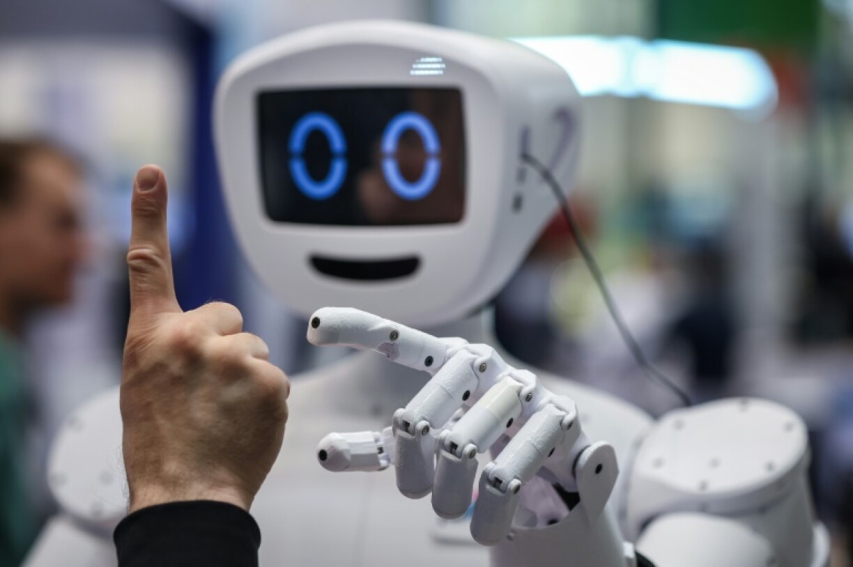 A man interacts with humanoid robot at the booth of the German Federal Ministry of Education and Research during the opening of the Hannover Messe