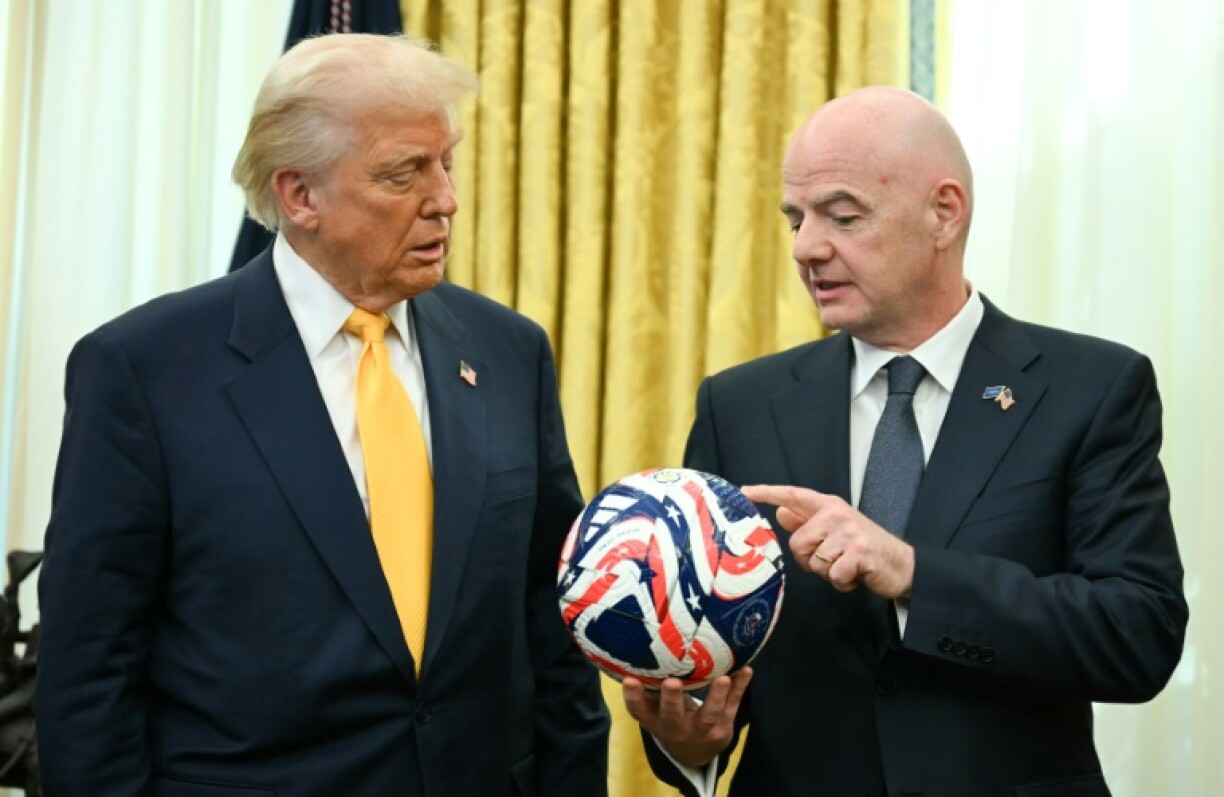 FIFA president Gianni Infantino (R) presents US President Donald Trump with the new FIFA Club World Cup official ball in the Oval office