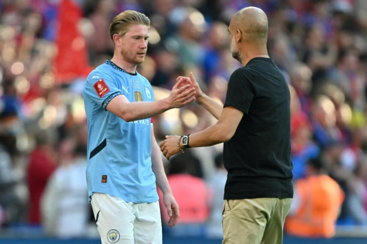 Manchester City's Kevin De Bruyne (L) shakes hands with Pep Guardiola