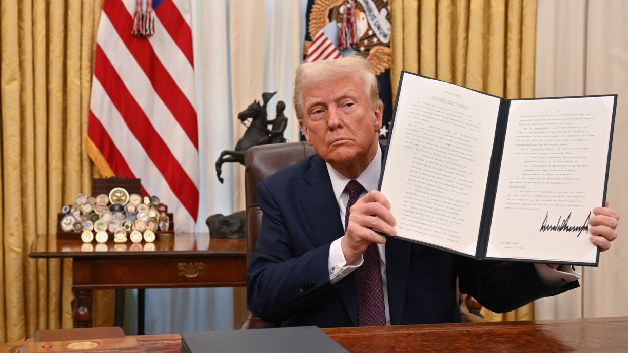 US President Donald Trump holds up an executive order he just signed to strenghten American leadership in digital financial technology, in the Oval Office of the White House on 23 January 2025.