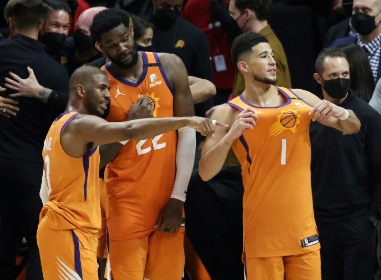 Devin Booker (d), Deandre Ayton (c) et Chris Paul des Phoenix Suns célèbre leur qualification en finale de la NBA après leur victoire chez les Los Angeles Clippers le 30 juin 2021