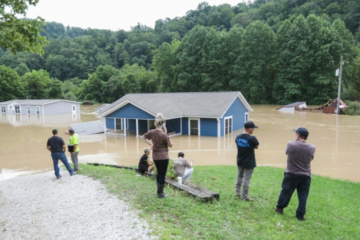 Une famille regarde sa maison inondée par des pluies torrentielles à Jackson, dans l'Etat américain du Kentucky, jeudi 28 juillet 2022
