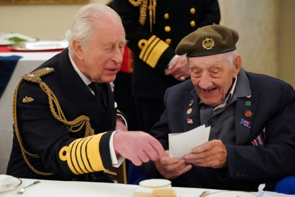 Britain's King Charles IIIspeaks with a World War II veteran during a tea party at Buckingham Palace