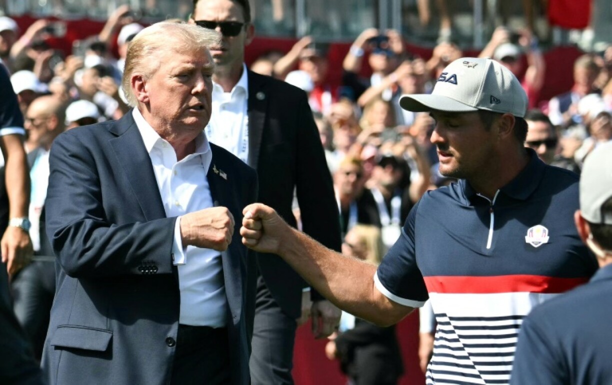 US President Donald Trump fist-bumps US golfer Bryson DeChambeau as he attends the Ryder Cup