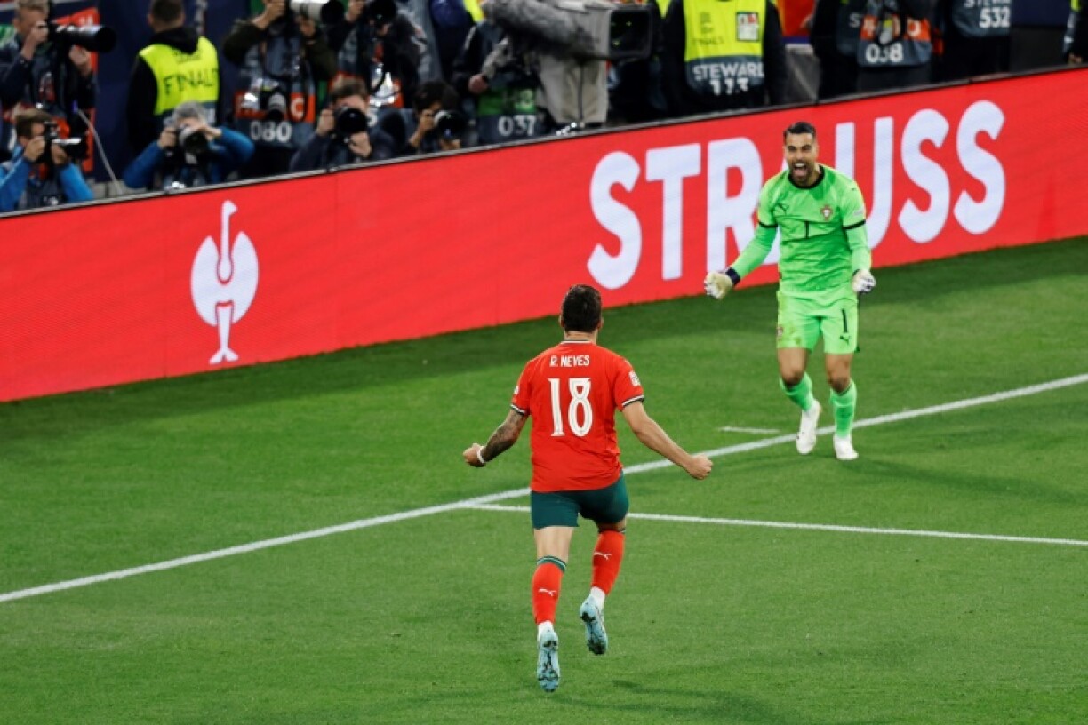 Ruben Neves runs toward Portugal's goalkeeper Diogo Costa after netting the winning penalty