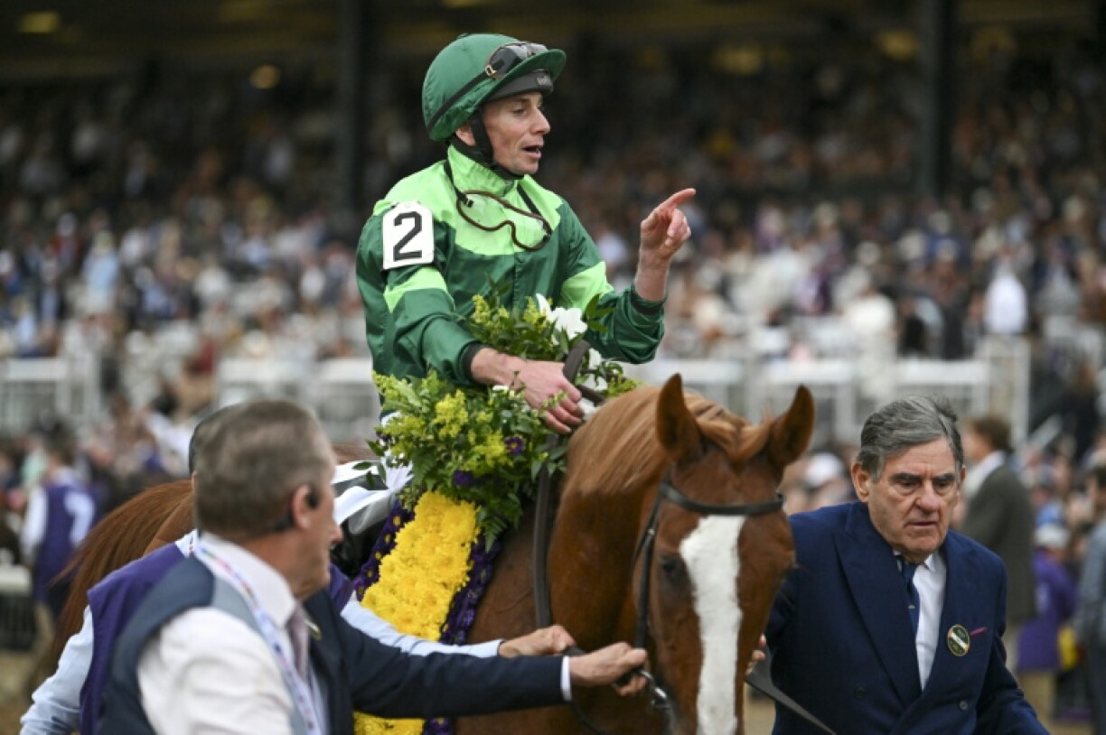 Jockey Ryan Moore, seated aboard Benvenuto Cellini, celebrates after winning the Breeders' Cup Turf at Keeneland Horse Track