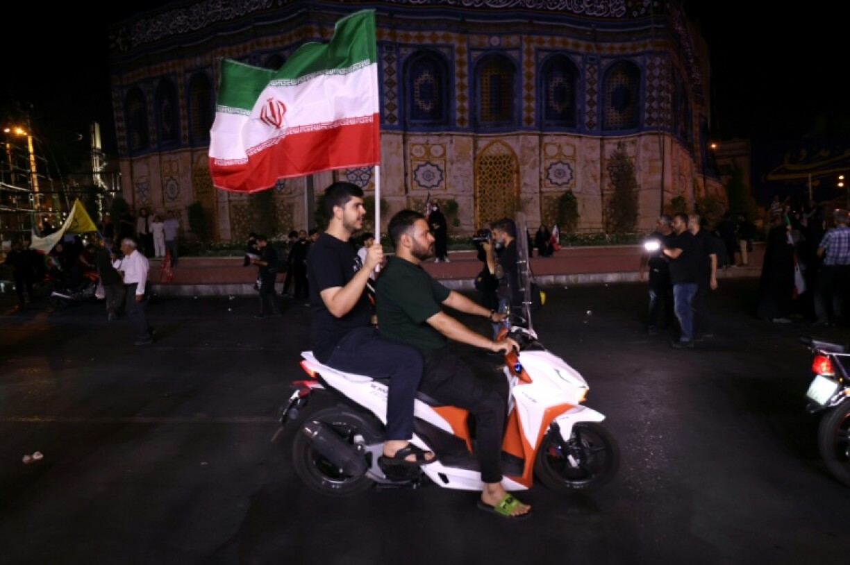 Iranians take to the streets to celebrate a missile strike that hit Tel Aviv.