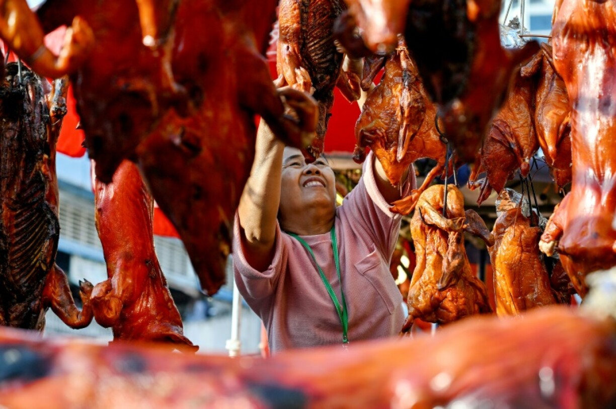 A vendor hangs a roasted pig for sale at a market in preparation for the Lunar New Year celebrations in Phnom Penh, Cambodia