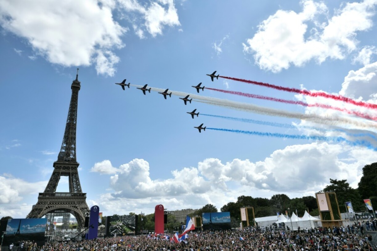 La Patrouille de France survole le Trocadéro rempli de spectateurs pour la cérémonie organisée à l'occasion du passage de relais olympique entre Tokyo et Paris le 8 août 2021