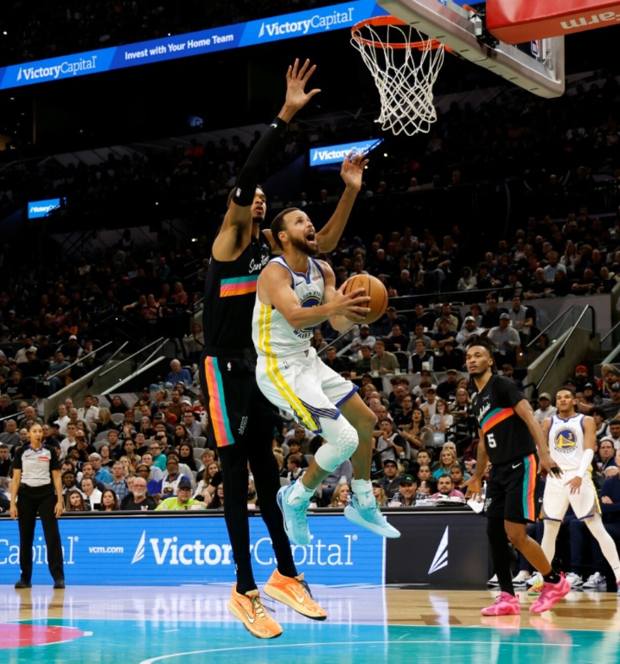 Stephen Curry of the Golden State Warriors scores against Victor Wembanyama in the Warriors' NBA victory over the San Antonio Spurs