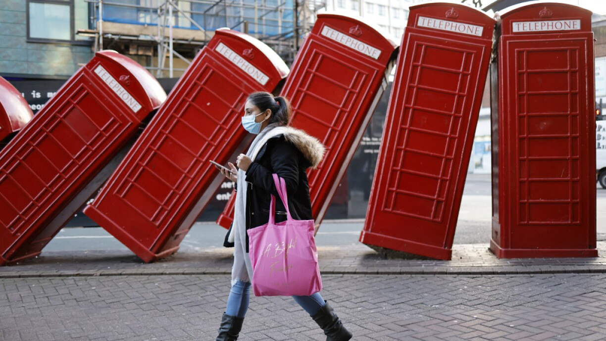 A shopper wearing a face covering to combat the spread of the coronavirus passes a piece of street art named 'Out of Order' by artist David Mach in the centre of Kingston upon Thames in south west London on January 9, 2022.