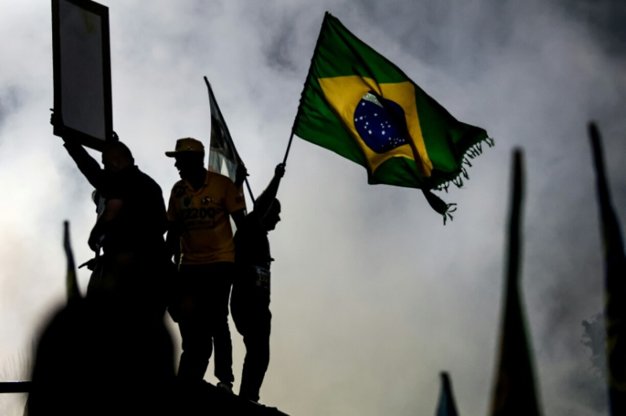 Un partisan du sénateur brésilien de droite et candidat à la présidence, Flavio Bolsonaro, agite un drapeau national lors d'un meeting de campagne à Rio de Janeiro, le 3 octobre 2026