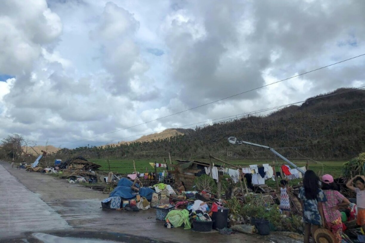 Des habitants de la ville de Dapa, sur l'île de Siargao, rassemblent quelques affaires après la destruction de leurs maisons par le typhon Rai, le 19 décembre 2021