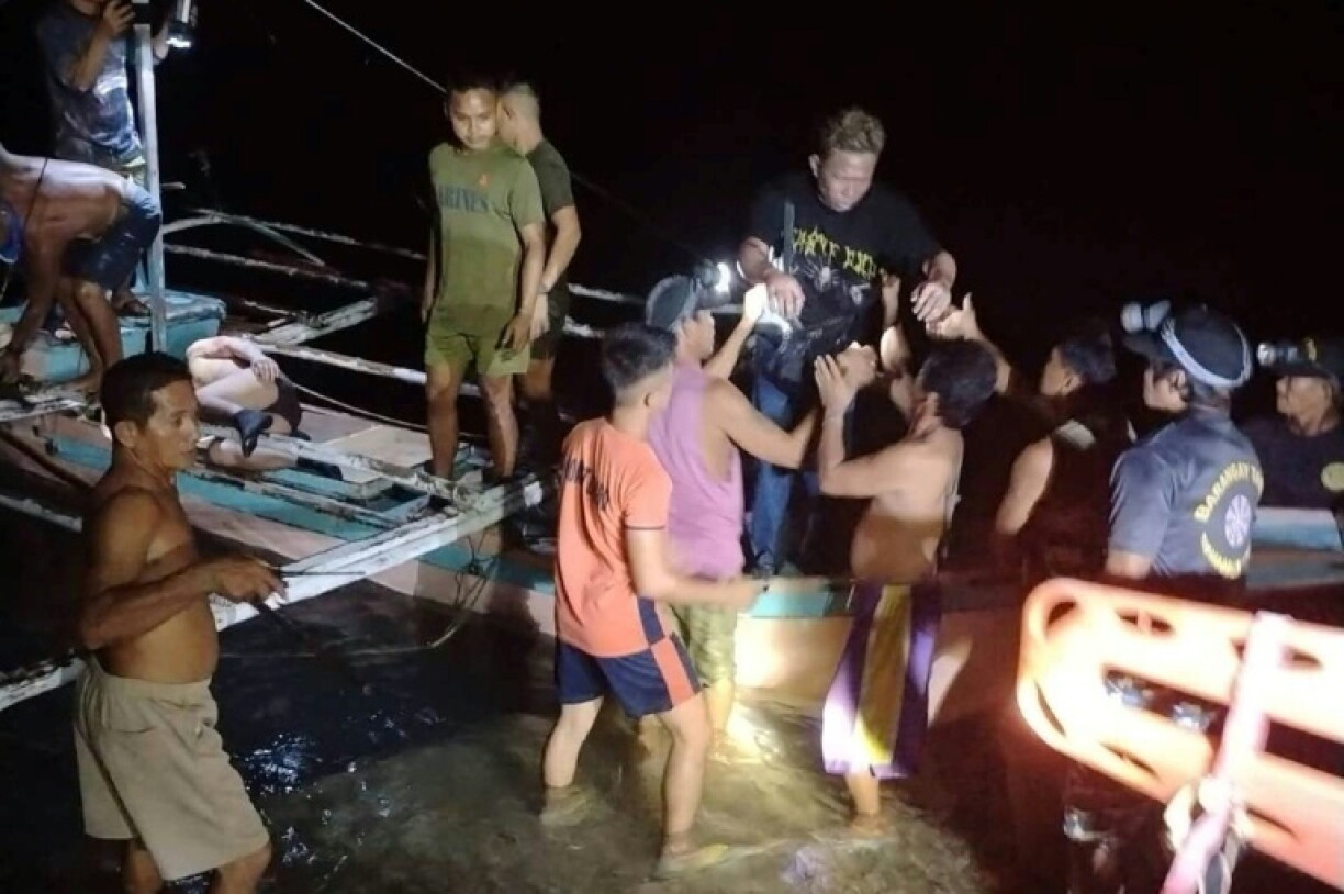 Cette photo fournie par la garde côtière philippine, prise le 9 septembre 2026 et reçue le 10 septembre 2026, montre des pêcheurs bénévoles venant en aide aux survivants du ferry qui a pris feu au large de Palawan, dans l'ouest des Philippines
