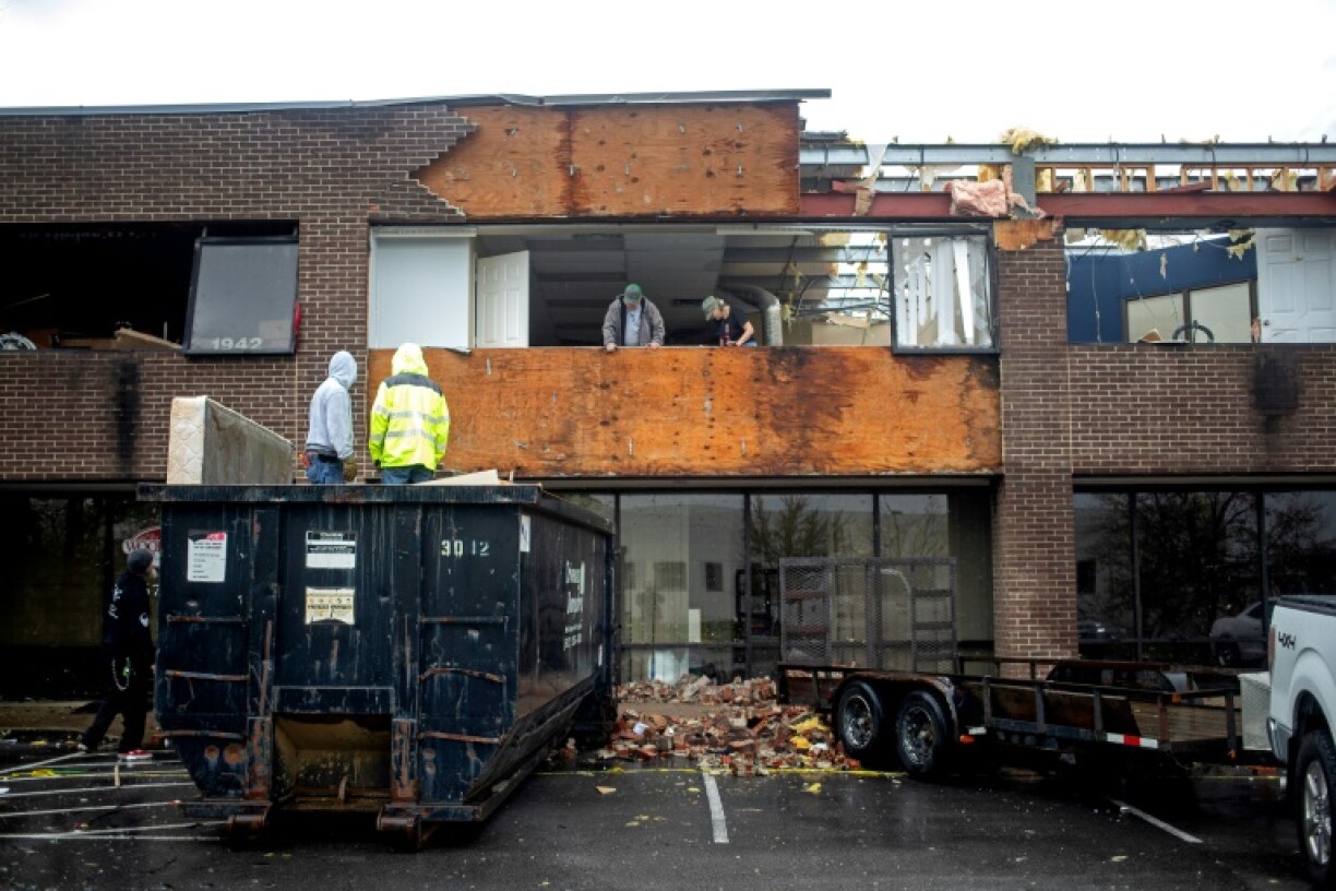 People remove debris from a building destroyed by a tornado in Louisville, Kentucky