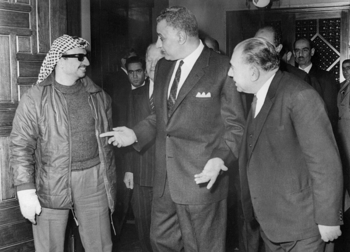 Picture of Palestine Liberation Organisation executive committee chairman Yasser Arafat (L) and Egyptian President Gamal Abel Nasser (C) taken on 4 February 1969 in Cairo during the National Palestinian Council.
