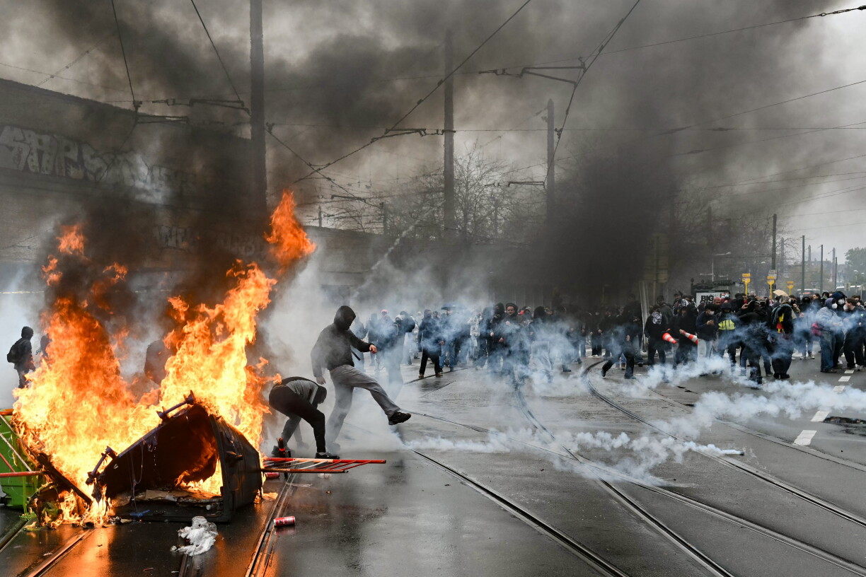 Un manifestant renvoie d'un coup de pied une grenade lacrymogène près de la gare de Bruxelles-Midi, à Bruxelles.
