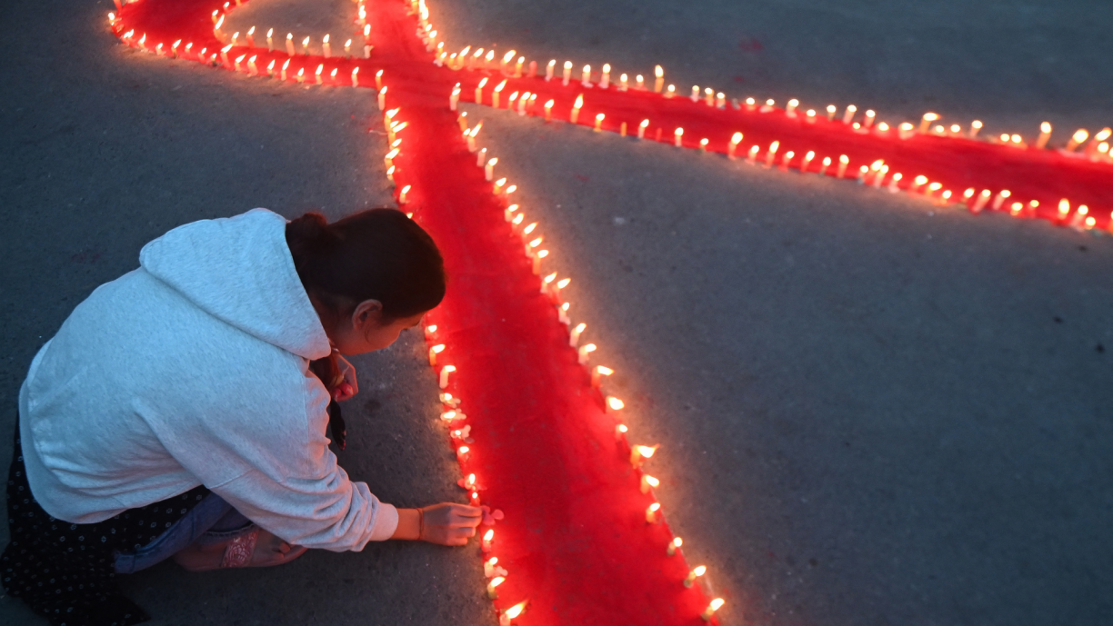 Volunteers’ light candles arranged in a red ribbon shape during an awareness event organised on the eve of ‘World AIDS day’ in Kathmandu on November 30, 2023